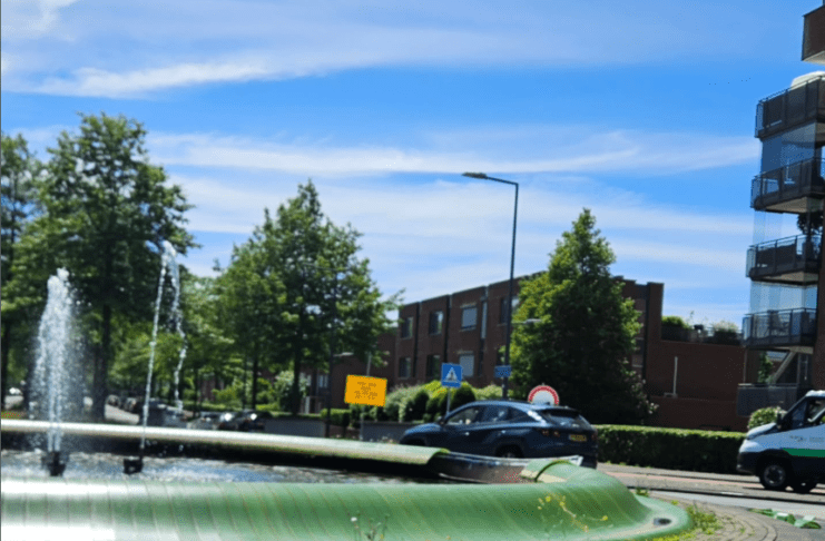 Auto rijdt groene fontein Nesselande in